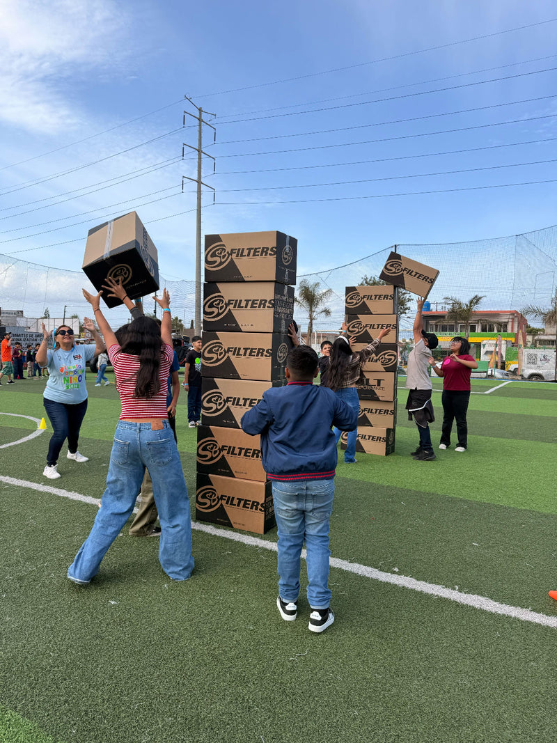 Children playing with cardboard boxes on a sports field, Childrens Day Celebration
