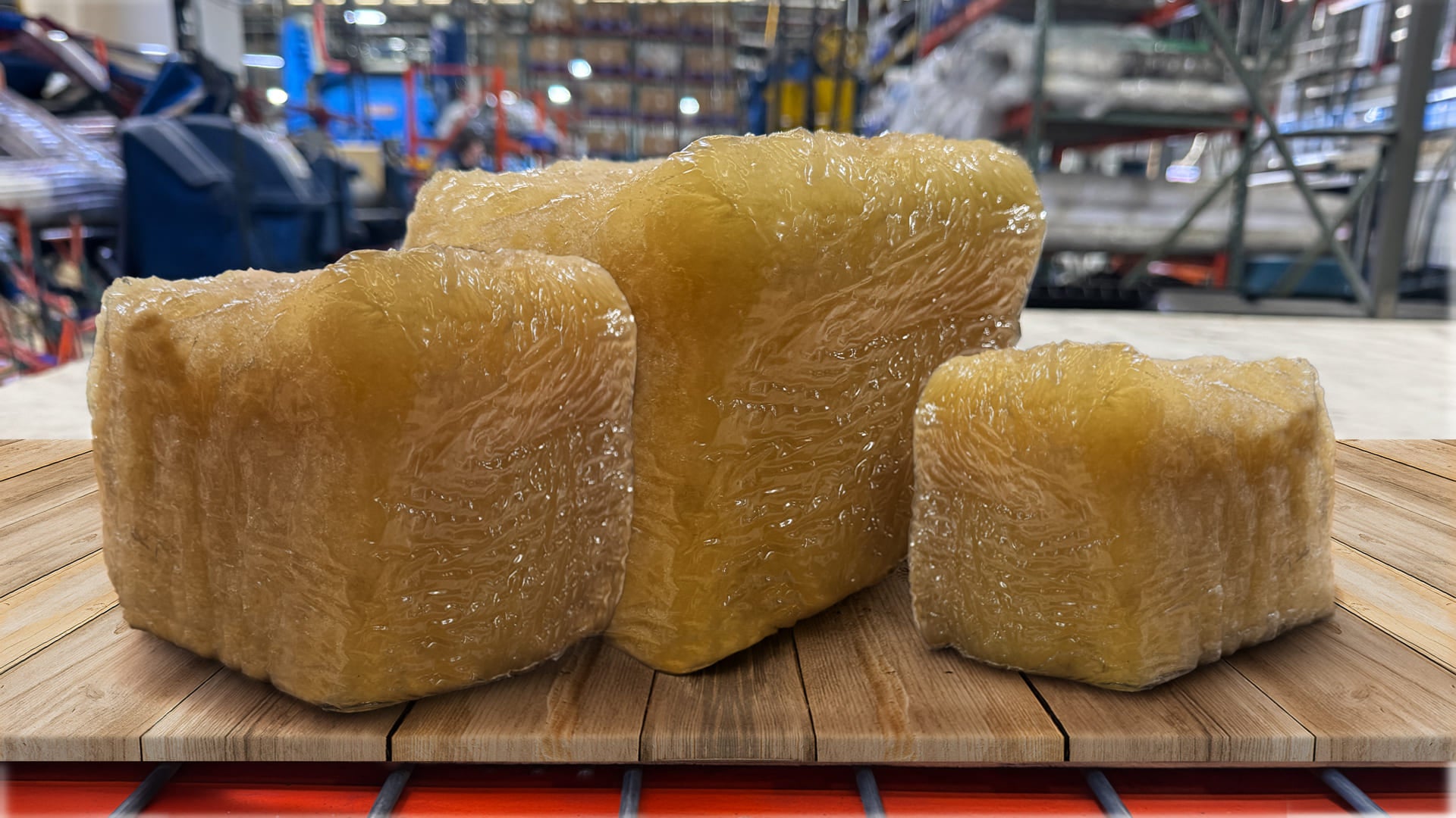 Three large blocks NBR (Nitrile) Rubber on a wooden pallet in a warehouse setting.