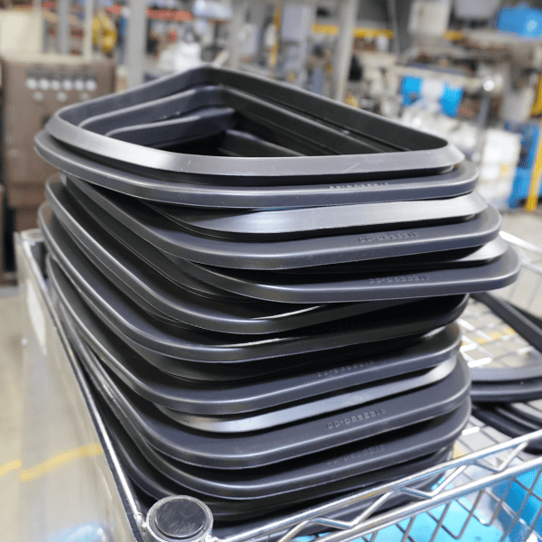 Stack of black window trim seals in a warehouse setting